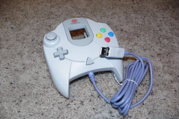 white color Dreamcast Controller on table surface
